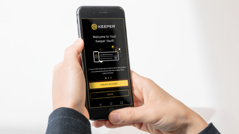 A phone being held with the password manager tool, Keeper, on the screen.