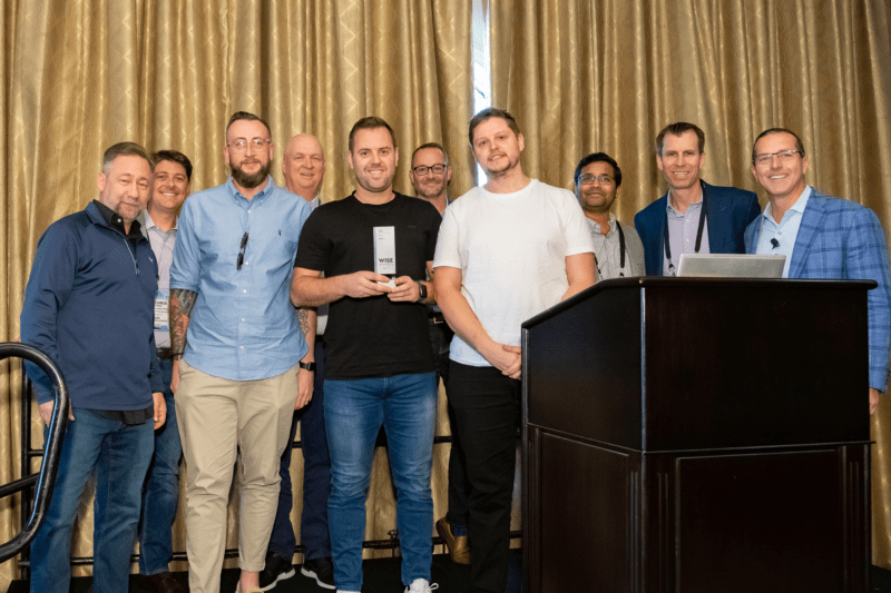 Three Air IT employees, Josh Tuner, James Healy and Lee Johnson, standing together on a stage collecting an award. 